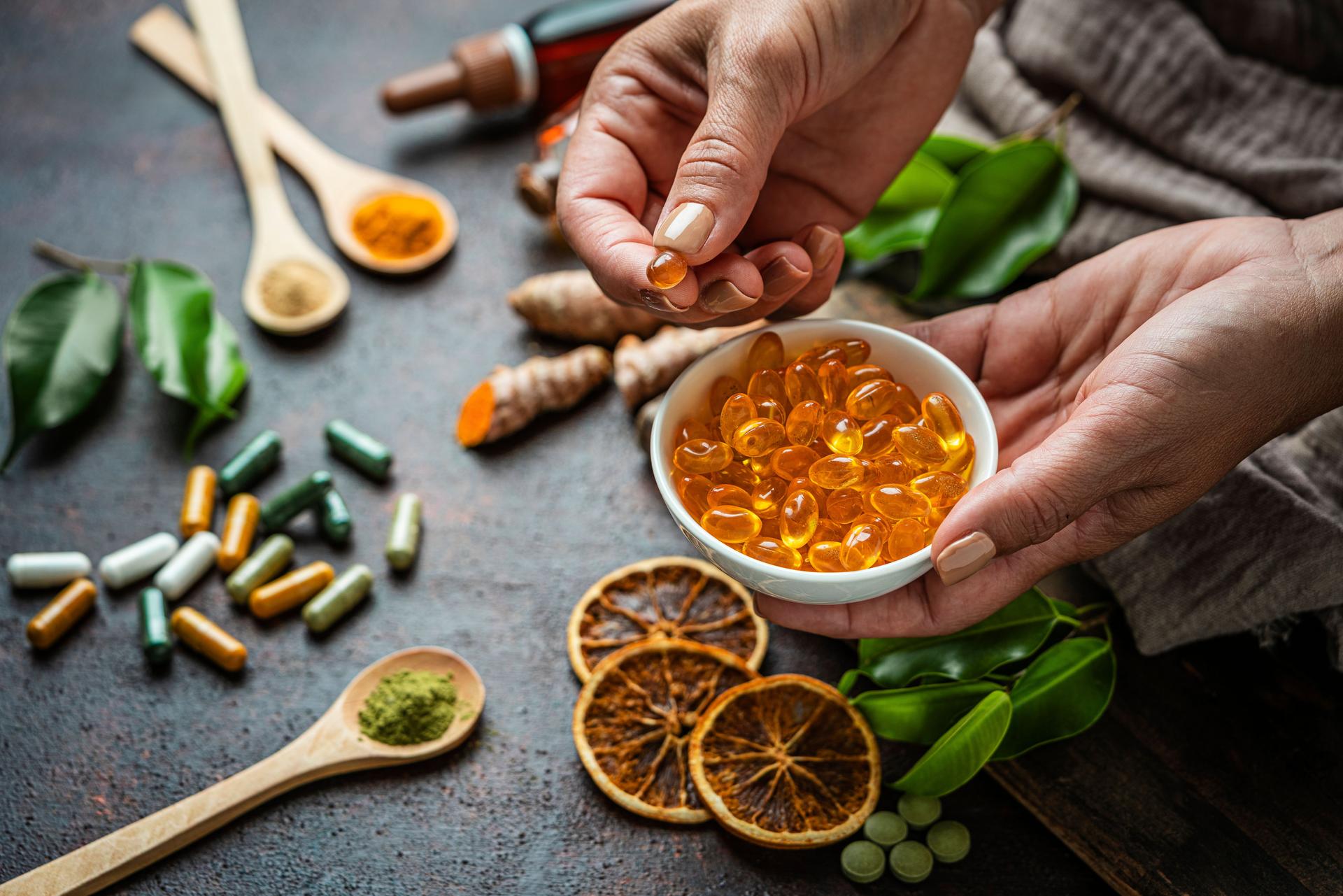Woman's hands holding a bowl filled with Omega-3 capsules. Nutritional supplements and alternative medicine or healthcare concept. Natural vitamins and healthy eating